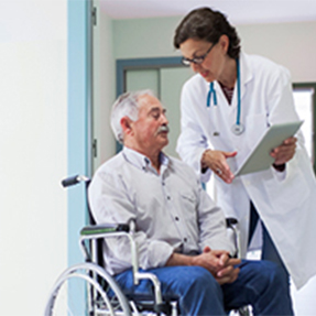 Doctor helping patient in wheelchair